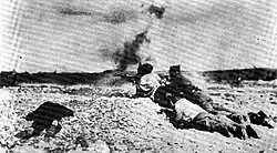 black and white photograph of men firing weapons