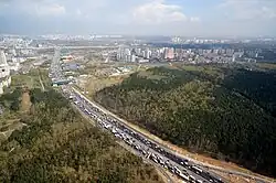 The Moscow Automobile Ring Road (MKAD) divides the former municipal districts of Vykhino (left) and Zhulebino (right). In the photo, there is Zhulebinskiy Zakaznik&nbsp;[ru] to the right of the MKAD.