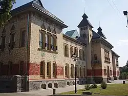 Photograph of a Ukrainian building with ornate tile and brick work on the façade, columned window dressings, and multiple towers