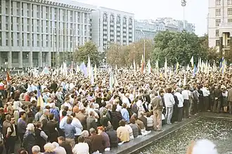 Several people with predominantly Ukrainian flags demonstrating in front of office buildings