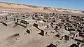 Some modern housing visible in the foreground with many other abandoned historical buildings