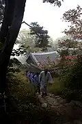 Monk and Templestay guests walk up a wooded path in the temple (2008)