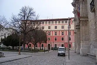 A town square with a palatial house in the background.