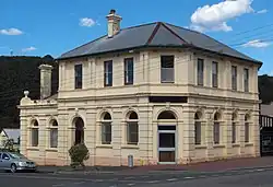 Former bank at 112 Main Street Zeehan. It was constructed by the Commercial Bank of Tasmania and opened in 1899.[41] It was merged into the English, Scottish and Australian Bank in 1921 and the ANZ Bank in 1970, but the branch was closed by ANZ in late 2016.