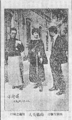 A black-and-white newspaper photo of three people