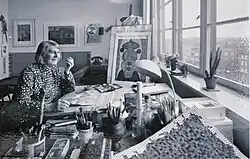 Grete Jürgens poses with her art supplies at her home studio