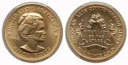 A gold medallion depicting a woman and comedy and tragedy masks