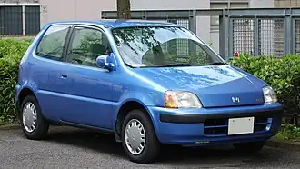 A small three-door car with an integrated headlamp and indicator cluster, door mirrors, and steel wheels with hubcaps