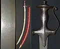 Talwar hilt with knuckle bow, 19th century, silver koftgari decoration, damascus steel blade.