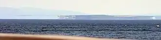 Distant shadowy appearances of land, seen across a wide expanse of sea