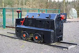 Une locomotive de mine restaurée avec des rails.