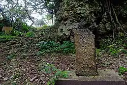 Near the entrance where the stone monument for "Buribuchi Park" stands.