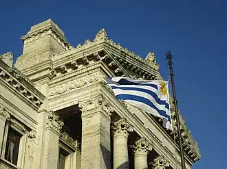 Uruguayan flag waving in front of the palace