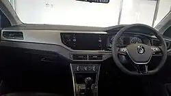 Dashboard of a car with front airbags, a manual gearbox, rotary air conditioning, heater, and audio controls, analogue and digital gauges, a screen which may be used for satellite navigation, USB 2.0 ports, and a glove box.