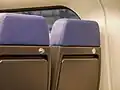 Retractable hooks on the seats of a railway train