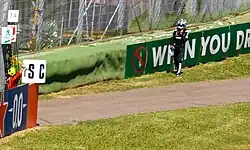 Antonelli walking past the barriers towards a marshal post after retiring from the 2025 Emilia Romagna Grand Prix