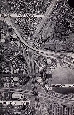 A black-and-white, aerial image of an urban area; visible are roads and buildings, a river, and labels saying "Island Expressway", "Meadow Lake", and "Worlds's Fair".