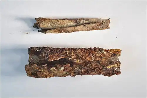Silver scroll (above) and lead case (below) after separation by conservator.