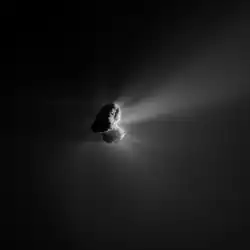 Black-and-white photograpj of an oddly-shaped object on a dark background. The right side is illuminated and has hazy lighter emanations.
