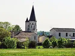 White church bell tower topped with a slate spire, round turret attached.