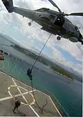 A member of an Algerian navy boarding team fast-ropes out of a Hellenic Navy S-70B-6 Aegean Hawk helicopter assigned to the 2nd Squadron onto the training ship Aris (A 74) at the NMIOTC