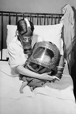 Mother and baby with gas masks, 1941