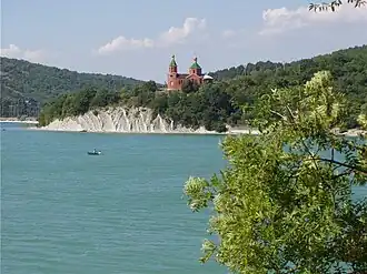 A lake with a church on the far shore