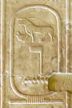 On a yellowish stone, cartouche inscribed with the hieroglyphs of a ram, above a flag-pole-like symbol and a wave of water