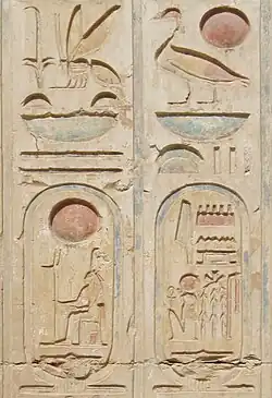 A stone face carved with coloured hieroglyphics. Two cartouches - ovoid shapes with hieroglyphics inside - are visible at the bottom.