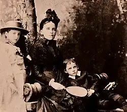 Ada Cambridge pictured sitting outside with her son Kenneth (aged around 6) sitting on her lap. Her daughter Vera (aged around 10) stands to her left.