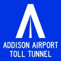A blue sign with a stylized "A" logo and the text "ADDISON AIRPORT TOLL TUNNEL"