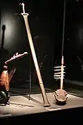 Center: six-string bowl zither (ligombo) of type B from the Nyamwezi in Central Tanzania. Missing gourd resonator.