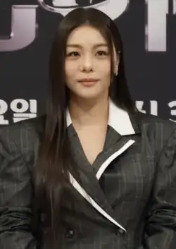 Ailee wearing a gray blazer and posing for the camera during Veiled Cup' production conference in 2026