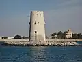 Al-Maqta' Tower (Arabic: بُرْج ٱلْمَقْطَع, romanized:&nbsp;Burj Al-Maqṭaʿ; front) and Al-Maqta' Fort (Arabic: حُصْن ٱلْمَقْطَع, romanized:&nbsp;Ḥuṣn Al-Maqṭaʿ; back), just outside the island of Abu Dhabi