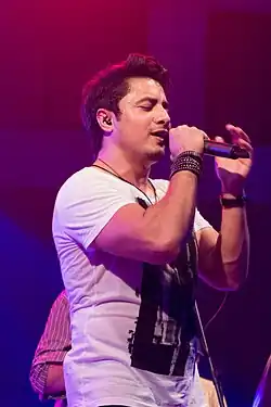 Photograph of person singing on a mic with stand