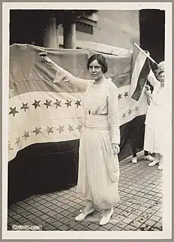 Alice Paul stands before the Woman Suffrage Amendment's ratification banner.