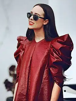 A woman wearing a burgundy dress and sunglasses.