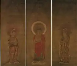 A red robed deity flanked by two attendants.