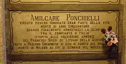 A marble gravestone on the wall of a crypt