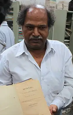 Gowda pictured holding a Canarese-English dictionary by Daniel Sanderson printed in 1838