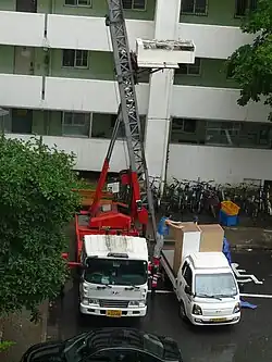 Monte-meuble en operación, elevando mobiliario hacia un piso alto.