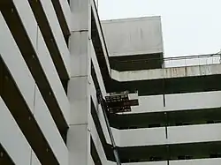 Elevador de mudanzas desplegado en fachada urbana, listo para carga pesada.