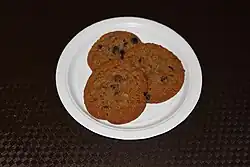 Brown cookies on a plate with small black pieces inside