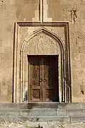 Western portal with a decorative tympanum.