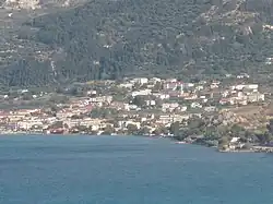 A collection of houses and other buildings on the shore of a blue ocean
