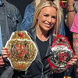 One-time champion Ash by Elegance holding the fourth and present TNA design (2024–present) (left, in her right hand)