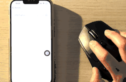 Animated GIF showing a Bluetooth mouse cursor selecting and dragging the AssistiveTouch floating button to a different location on the iOS screen.