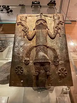 Relief plaque showing a king (Oba) dominating leopards; c. 1530–1570; copper alloy; 37.5 × 19.1&nbsp;cm (143⁄4 × 71⁄2 in.); Royal Bronze-casting Guild (Igun Eronmwon), Edo, Benin kingdom, Nigeria; Museum of Fine Arts, Boston (accession L-G 7.23.2012)