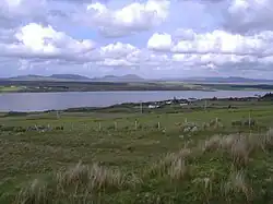Fields and a bay, with mountains in the distance