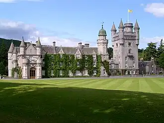 Balmoral Castle, with the Royal Standard of Scotland flying from a flagpole mounted on the roof of its cap-house